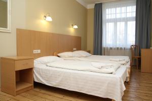里加雅可布仁兹宾馆的一间卧室配有一张大床和木制床头板
