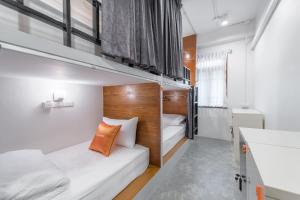 曼谷小小塔拉奈伊旅舍的一间小房间,设有两张双层床和一间浴室