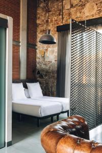 巴塞罗那巴塞罗那共和公寓酒店的一间设有两张床和真皮沙发的房间