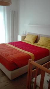 阿科Appartamento caneve的一间卧室配有红色床单和黄色枕头。