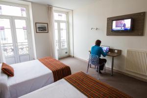 格勒诺布尔欧洲格勒诺布尔超级中心酒店的坐在酒店房间桌子上的女人