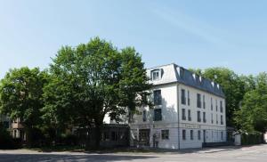 梅明根恩格尔凯勒餐厅酒店的前面有棵树的白色建筑