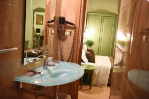 卢切拉Hotel Federico II的一间带水槽和镜子的浴室