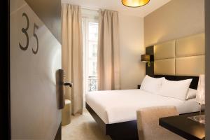 巴黎马莱驿站酒店的酒店客房设有白色的床和窗户。