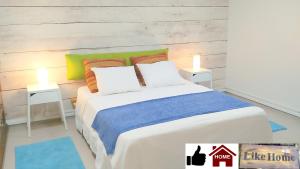 GederaLike Home Gedera的卧室配有一张带两张桌子的大型白色床