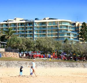 穆卢拉巴地标度假酒店的一家家庭在海滩上散步,酒店背景良好