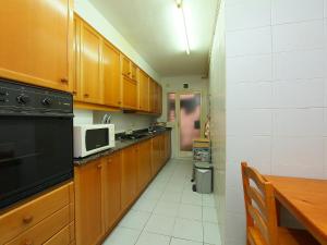 滨海托萨Apartment Rambla de Tossa by Interhome的厨房配有木制橱柜、桌子和微波炉