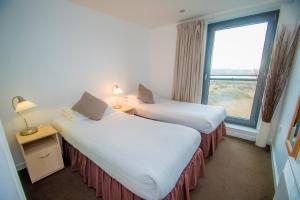 爱丁堡Ocean Serviced Apartments的配有窗户的酒店客房内的两张床