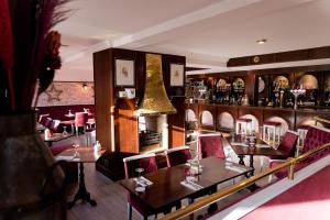 阿伯丁Leys Hotel的一间带桌椅的餐厅和一间酒吧