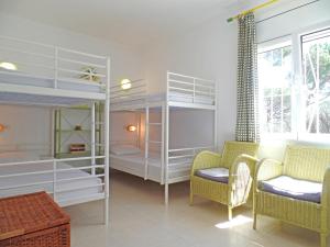 莱斯卡拉Casa Bel Coll的带两张双层床和两把椅子的房间