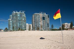 黄金海岸海滨沉思酒店的海滩上高楼,有黄色和红色的旗帜
