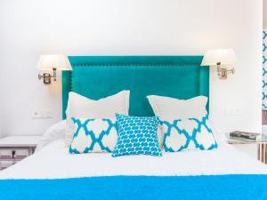 林孔-德拉维多利亚Villa Zurbarán by Interhome的一张带蓝色和白色枕头的床