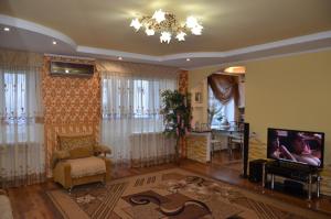 BerdychivLupova Home的一间带电视和吊灯的客厅