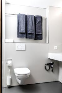 伦策海德Revier Mountain Lodge Lenzerheide的白色浴室设有白色卫生间和毛巾。