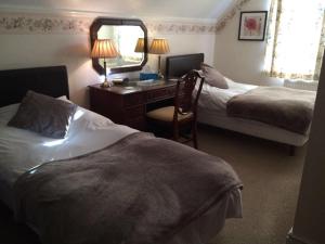 伊斯特布恩比奇莱丝酒店的酒店客房设有两张床、一张桌子和一面镜子