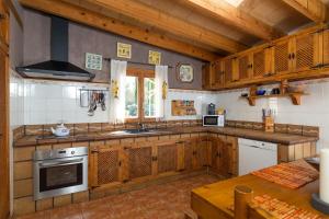 森瑟勒斯Mostatxet的厨房配有木制橱柜和炉灶烤箱。