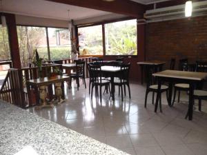 伊瓜苏港Petit Hotel Panambi的用餐室设有桌椅和窗户。