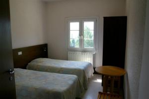 欧龙欧龙科莱酒店的客房设有两张床、一张桌子和一扇窗户。