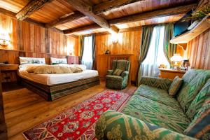 格雷索拉特里尼泰约兰达运动酒店的一间卧室配有一张床和一张沙发