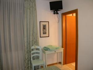 威尼斯阿杜阿酒店的配有桌子、椅子和电视的房间