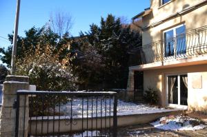安热尔桑新月住宿加早餐酒店的地面上积雪的房子前的围栏