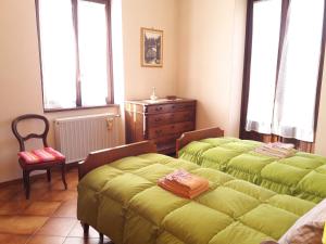 CavallascaComo Country House的一间卧室设有两张床、一个梳妆台和窗户。