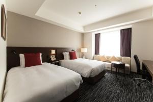 米子市米子市全日空皇冠假日酒店的酒店客房,设有两张床和一张沙发