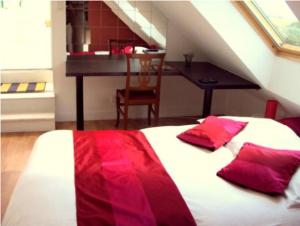 奎恩安杜娜荣旅馆的一间卧室配有一张带红色枕头的床和一张书桌