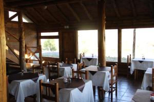 阿卢米内Montaña Negra的餐厅配有桌椅和白色桌布
