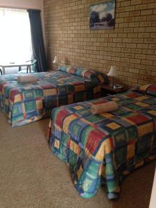 WudinnaWudinna Gawler Ranges Motel and Caravan Park的酒店客房带两张床和砖墙