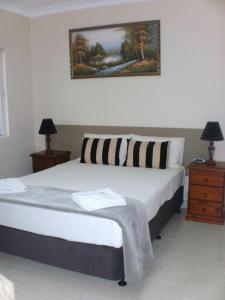 莫里莫里卡泉汽车旅​​馆的一间卧室配有一张大床,设有两个床头柜和两盏灯