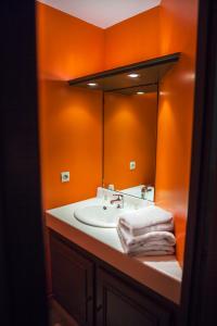 拉比谢尔The Originals City, Le Cottage Hôtel, Bruay-la-Buissière (Inter-Hotel)的橙色浴室设有水槽和镜子