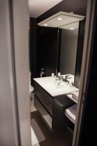 拉比谢尔The Originals City, Le Cottage Hôtel, Bruay-la-Buissière (Inter-Hotel)的浴室设有白色水槽和镜子