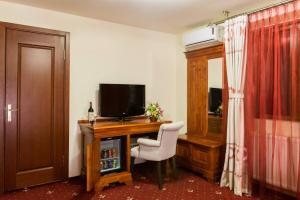 亚历山德里亚Red Hotel的客房设有书桌、电视和椅子