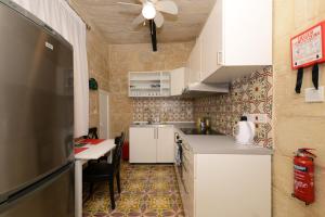 瓦莱塔Vallettastay Lovely House Private Rooms的厨房配有白色橱柜、桌子和天花板