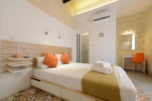 瓦莱塔Vallettastay Lovely House Private Rooms的一间卧室配有一张带橙色枕头的大床