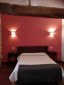 Pesquera de Duero拉波萨达德佩斯克拉宾馆的卧室配有一张带两盏灯的墙壁床。