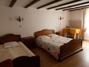 马尔穆捷Aux Deux Clefs的一间卧室配有两张床和一张桌子