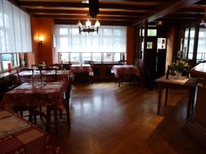 马尔穆捷Aux Deux Clefs的餐厅设有桌椅和大窗户。