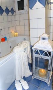 萨摩斯Aria Hotel Samos Town的带浴缸、带毛巾和蜡烛的桌子的浴室