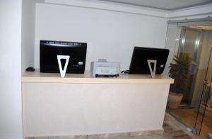 萨摩斯Aria Hotel Samos Town的上面有两台笔记本电脑的柜台