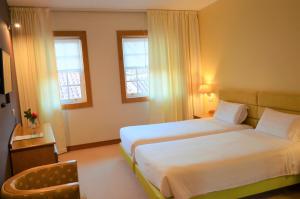吉马良斯图罗酒店的酒店客房带两张床和两个窗户