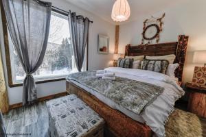 拉马巴耶Le Vanilee - Les Chalets Spa Canada的一间卧室设有一张大床和一个窗户。