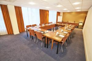 哈莱姆法兰斯哈尔斯阿姆拉斯大酒店的大型会议室,配有长桌子和椅子