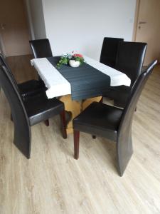 莱奥冈Appartement Haus Petra的一张桌子、四把椅子和一张黑桌子及椅子