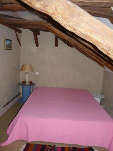 Saint-AlvèreLa Guelta的一间卧室配有一张带粉色毯子的床