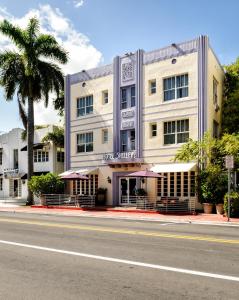 迈阿密海滩雪莱酒店的一条棕榈树街道上的白色大建筑