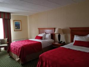 米斯蒂克Mystic River Hotel & Suites的酒店客房,配有两张带红色床单的床