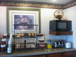 杰克逊杰克逊行政套房酒店 的厨房配有带微波炉和一些食物的柜台