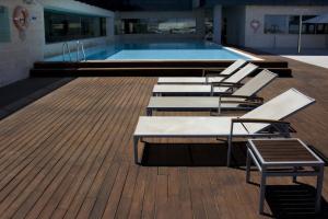 圣佩德罗-德尔皮纳塔尔穆尔西亚海岸塔拉西亚酒店的游泳池旁甲板上的一排躺椅